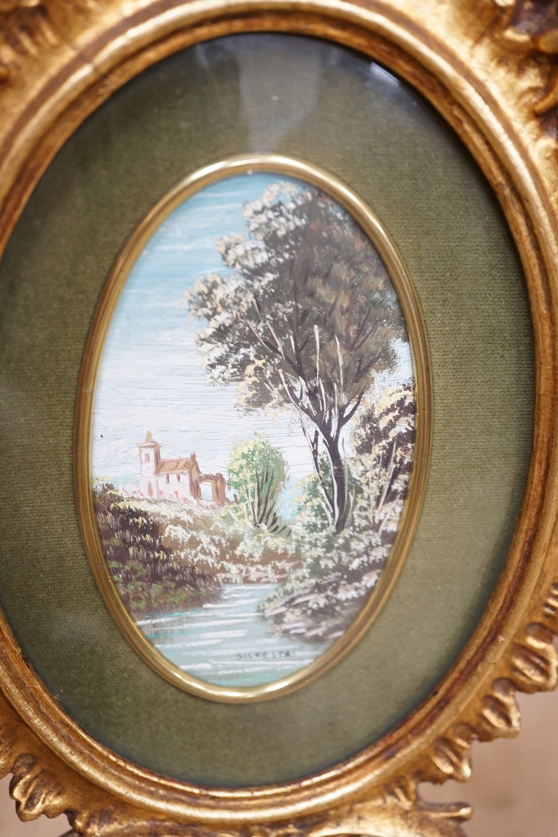 A pair of miniature Italianate landscapes, with pierced, carved oval giltwood frames. 29cm high overall